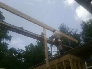 Carpenter setting a ridge beam over a new addition frame — Ice Dam Removal by Roofing Brothers in Eastchester