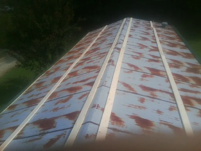 Rusted metal roof panels with new wood purlins before replacement — Storm Damage Roof Repair in Eastchester by Roofing Brothers