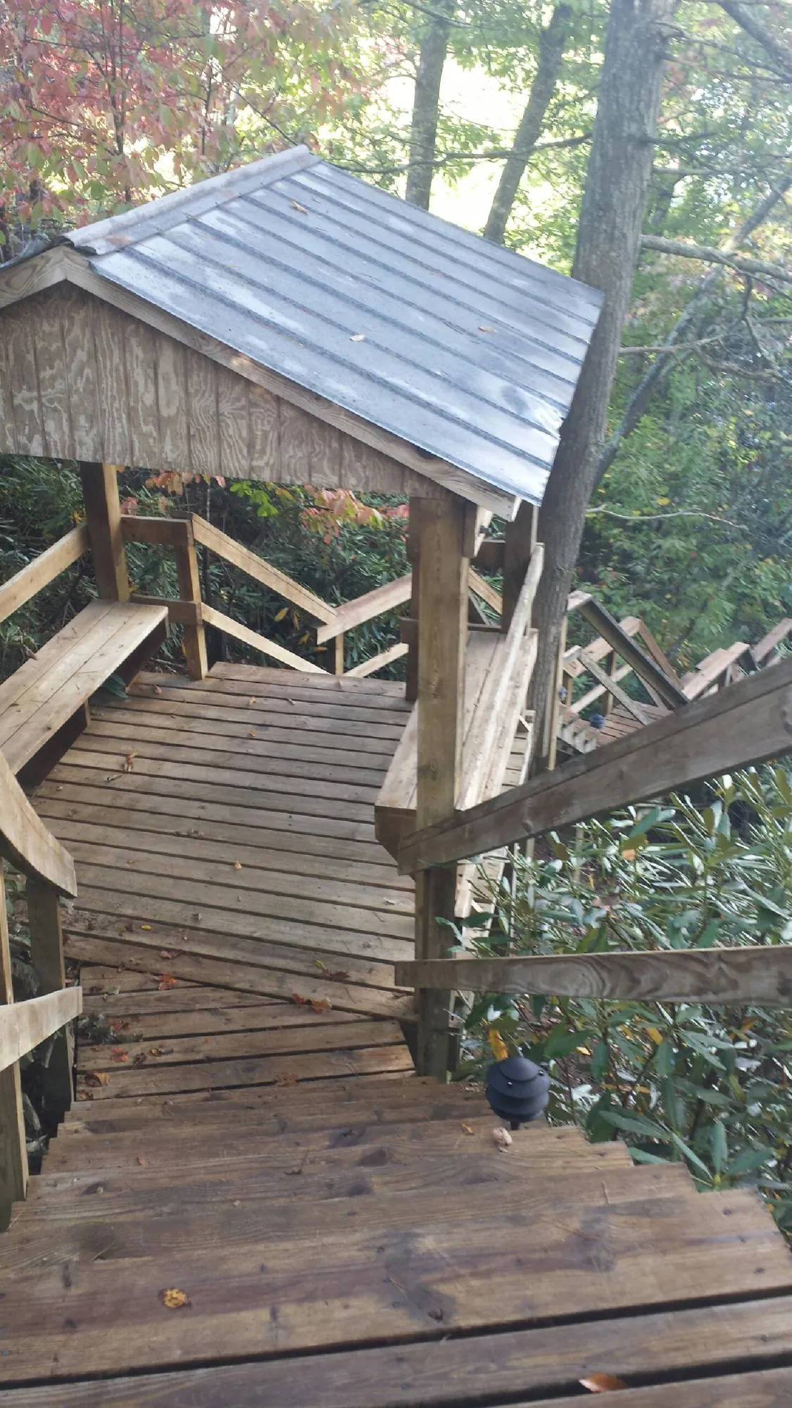 Metal roofed shelter over wooden steps on a wooded walkway — Skylight Repair & Installation work by our crew in Eastchester